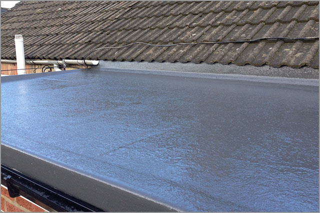 Flat GRP roof abutting a tiled pitched roof